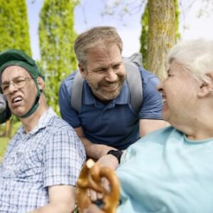 Auf dem Bild sind 3 Männer und eine Frau zu sehen. Sie befinden sich in der Natur und sehen gut gelaunt aus.